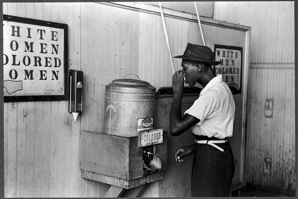 Man drinking at a water cooler reserved for "Colored," Oklahoma City, Oklahoma, 1939.